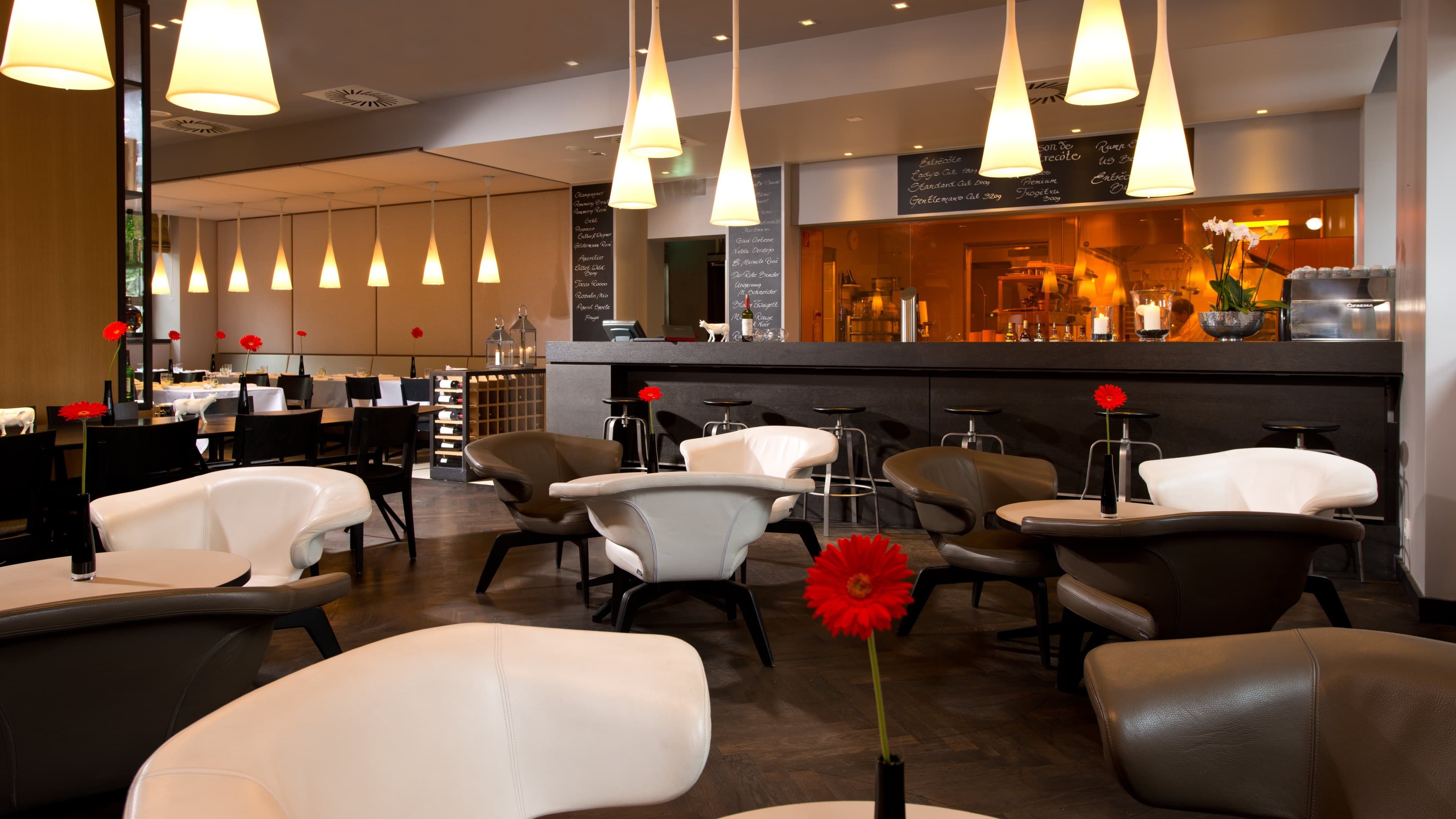 Real dining room with pendant lights, lounge seating, and warm evening atmosphere