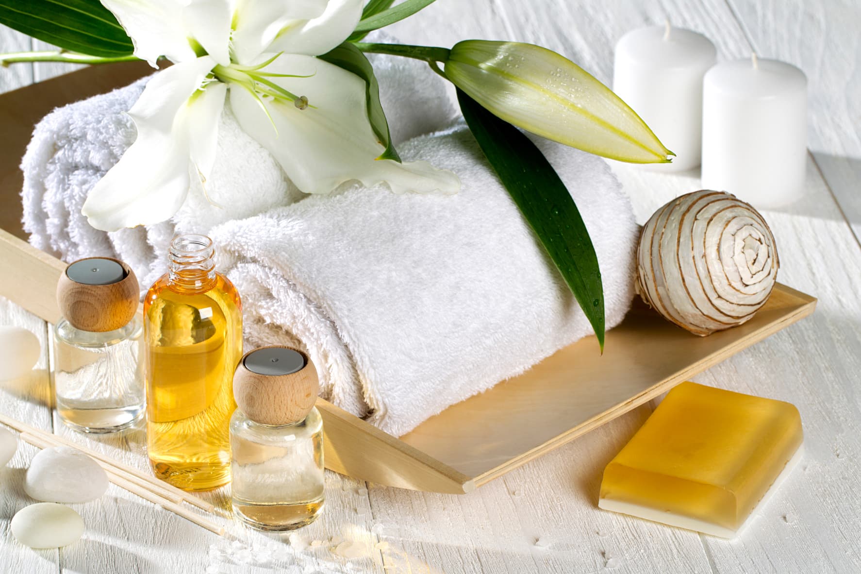 Real spa and bathroom amenity detail with towels, candles, and wellness oils